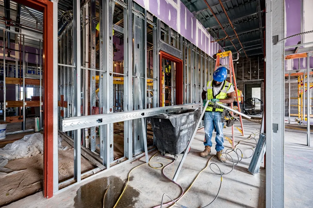 Construction worker framing walls inside a building being renovated