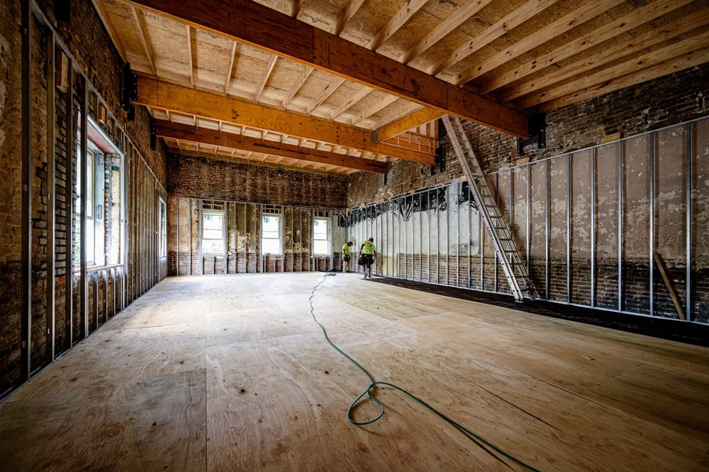 Open room stripped to the studs and subfloor during a renovation
