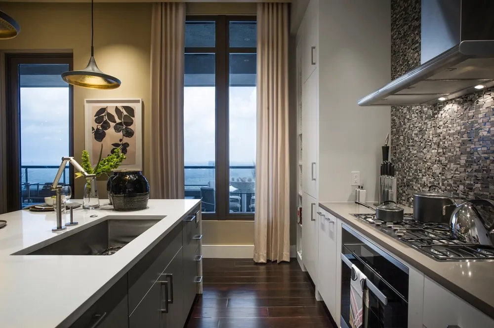 Modern kitchen with a sink under a tall window and gas cooktop
